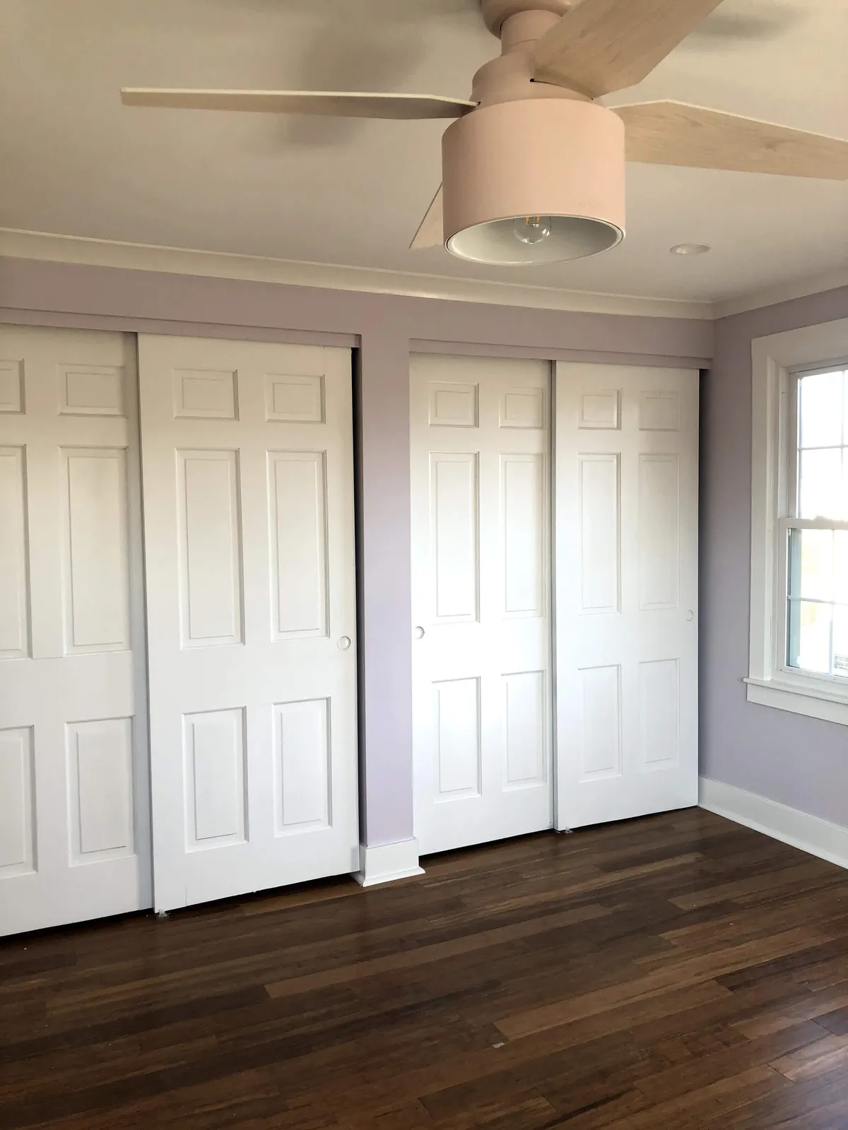 Interior closet doors installed and painted alongside newly finished hardwood flooring