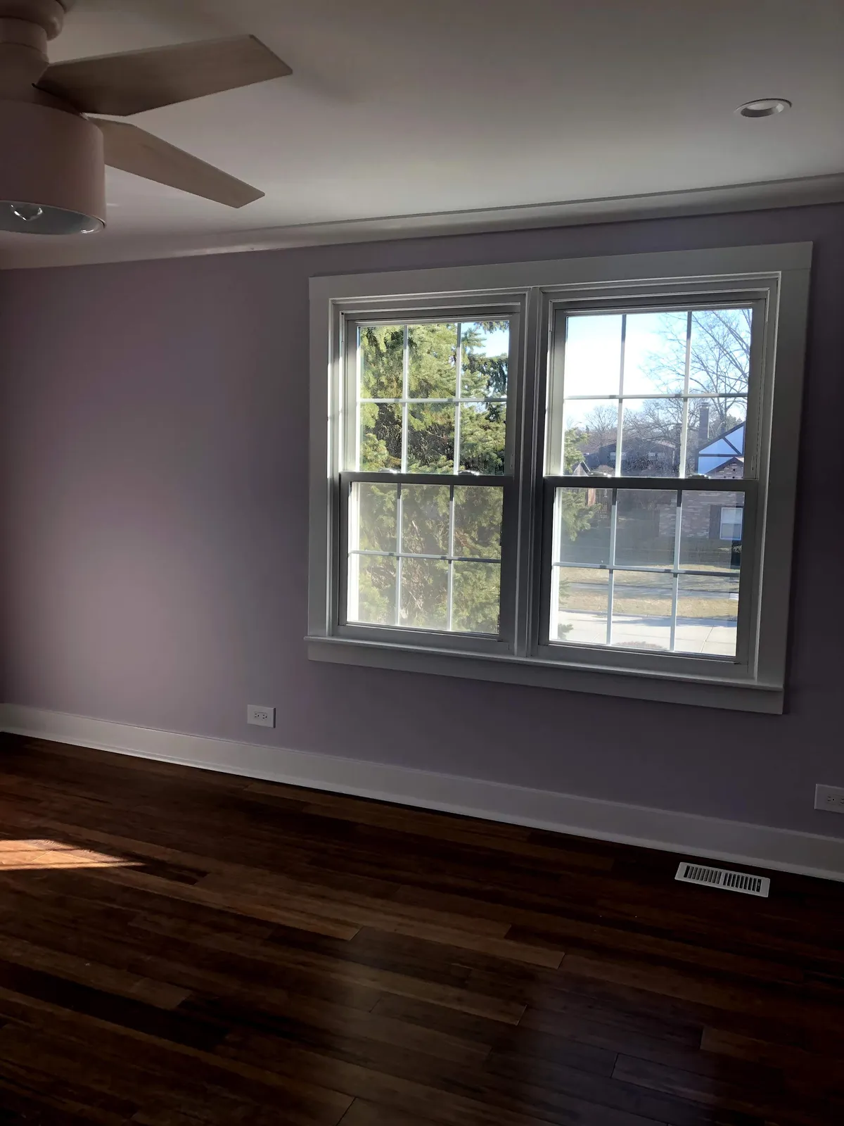 Freshly painted bedroom with new window trim and hardwood floors in a Chicago home