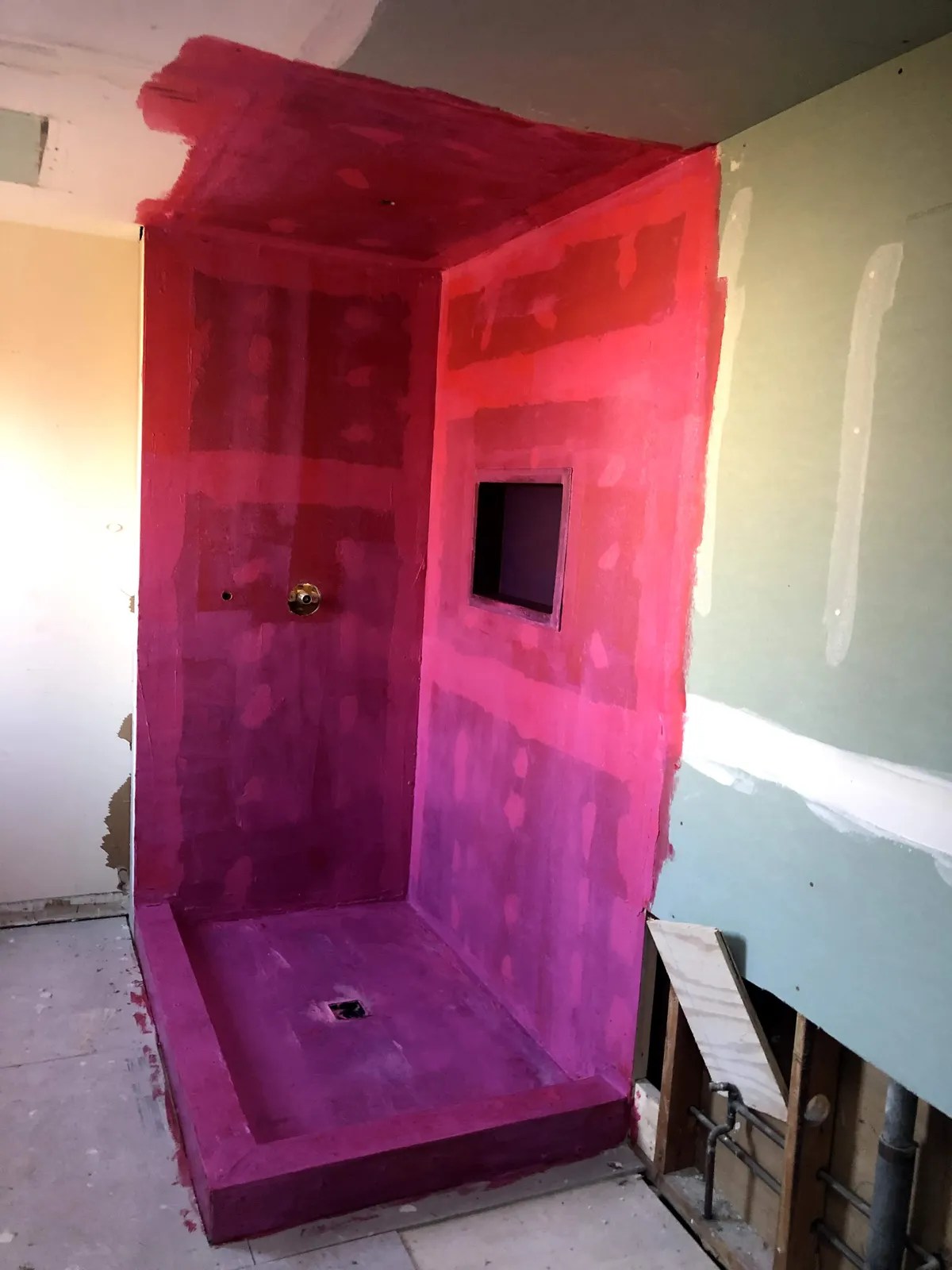 Shower walls prepared and waterproofed ahead of tile installation in a bathroom remodel
